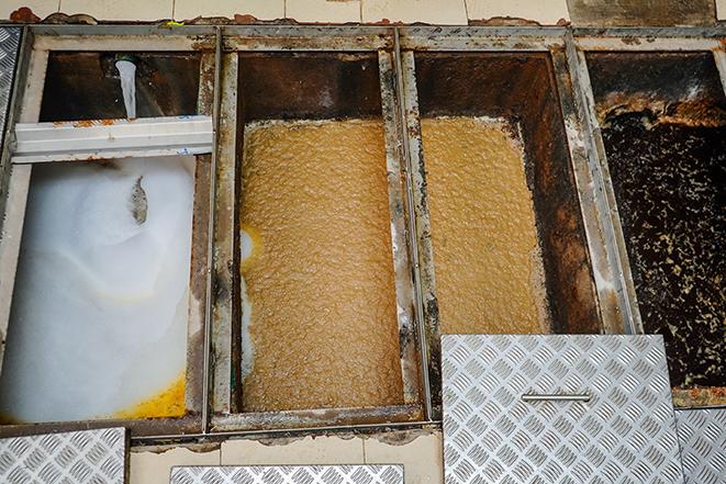 a grease trap being professionally cleaned by a technician